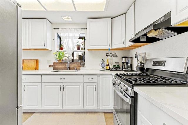 kitchen featuring sink, white cabinetry, light stone countertops, stainless steel appliances, and ventilation hood