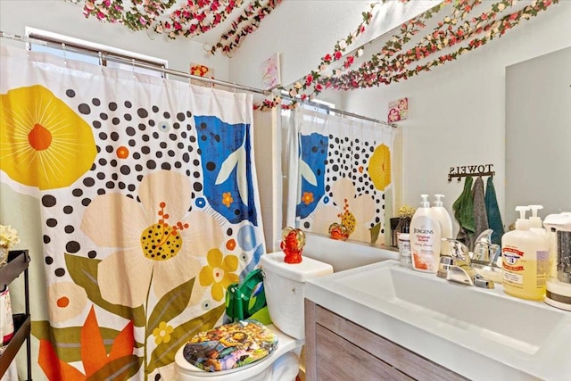 bathroom featuring toilet, vanity, and a shower with shower curtain