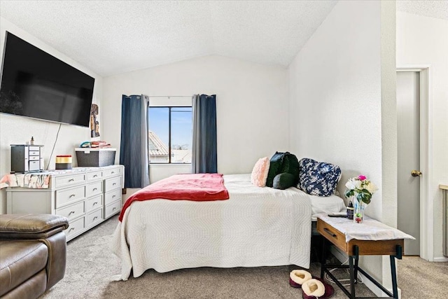 bedroom with a textured ceiling, lofted ceiling, and light colored carpet