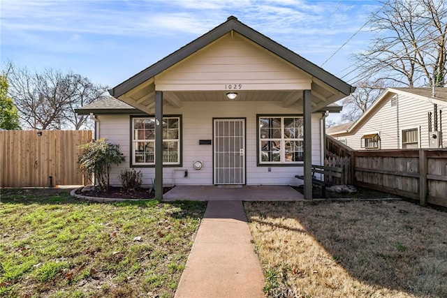 bungalow with a front lawn and covered porch