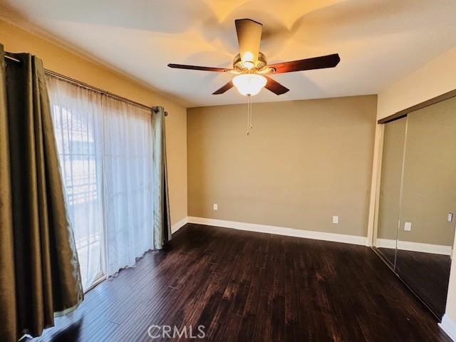 unfurnished bedroom featuring ceiling fan, a closet, and dark hardwood / wood-style floors