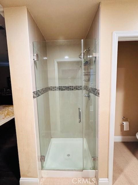 bathroom with toilet, tile patterned floors, and an enclosed shower