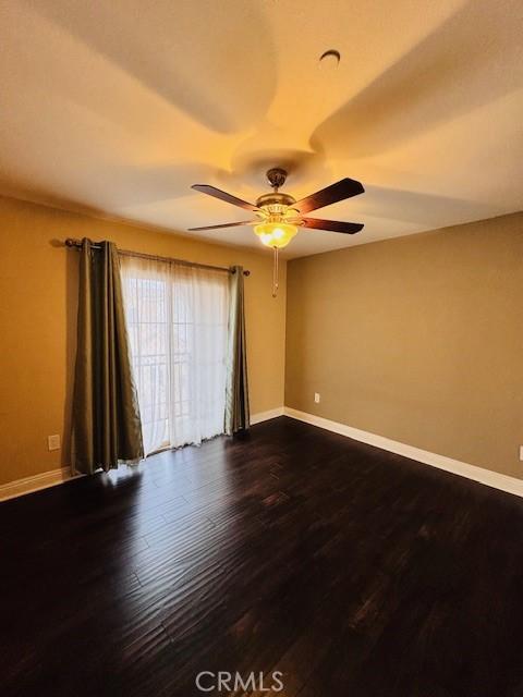 unfurnished room with ceiling fan and dark hardwood / wood-style flooring