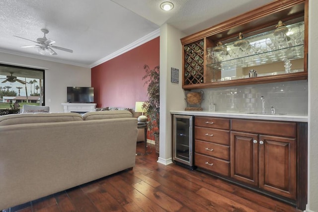 bar with wine cooler, dark hardwood / wood-style floors, decorative backsplash, sink, and crown molding