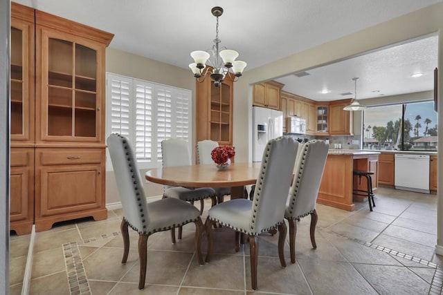 dining space with light tile patterned floors and a notable chandelier