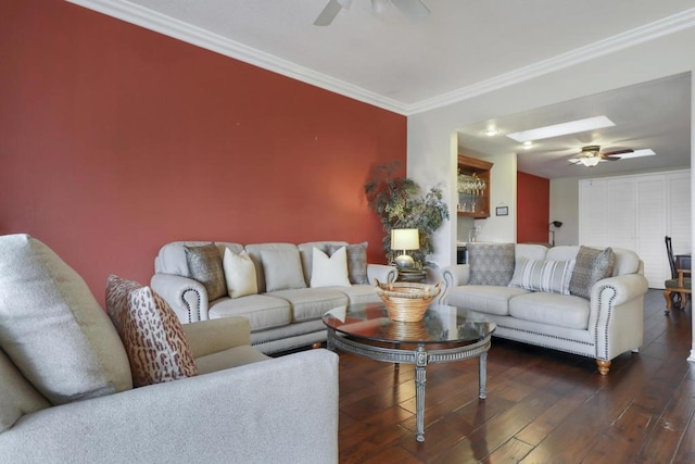 living room with ceiling fan, a skylight, dark hardwood / wood-style flooring, and ornamental molding