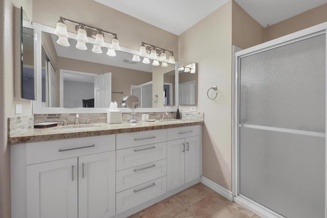 bathroom with vanity, tile patterned floors, tasteful backsplash, and walk in shower