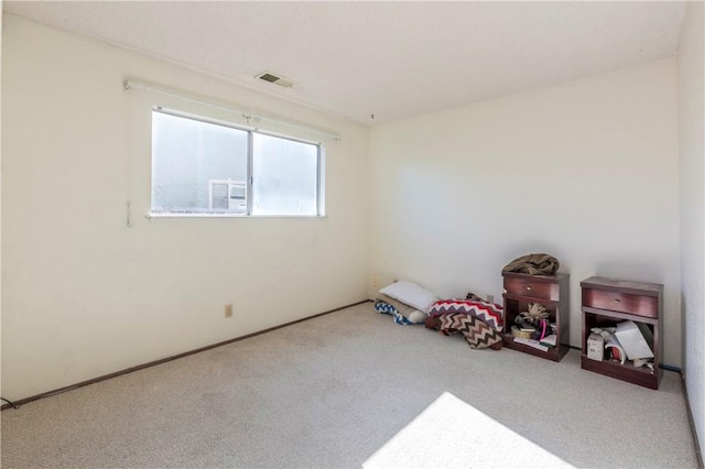 spare room featuring carpet, visible vents, and baseboards