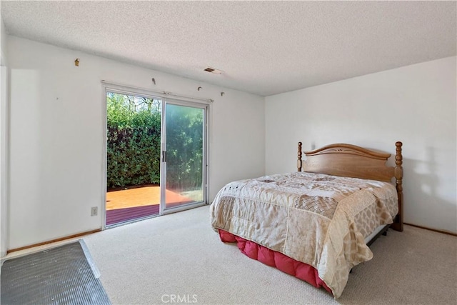 bedroom with access to outside, carpet flooring, visible vents, and a textured ceiling