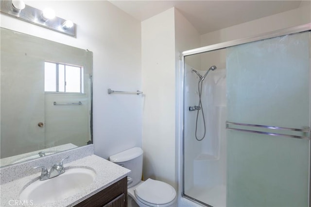 full bath featuring a stall shower, vanity, and toilet