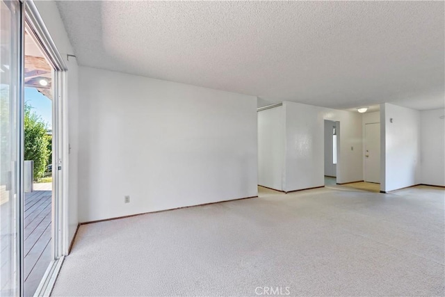 empty room featuring a textured ceiling and light carpet