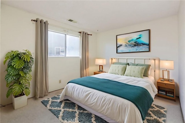 bedroom featuring visible vents and light carpet