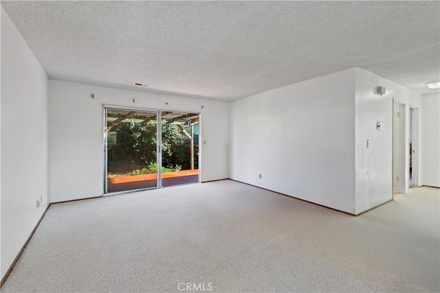 carpeted spare room featuring a textured ceiling