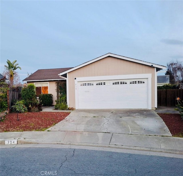 view of front of house with a garage, driveway, and fence