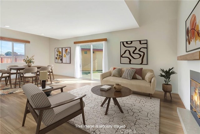 living room featuring a high end fireplace and light hardwood / wood-style floors