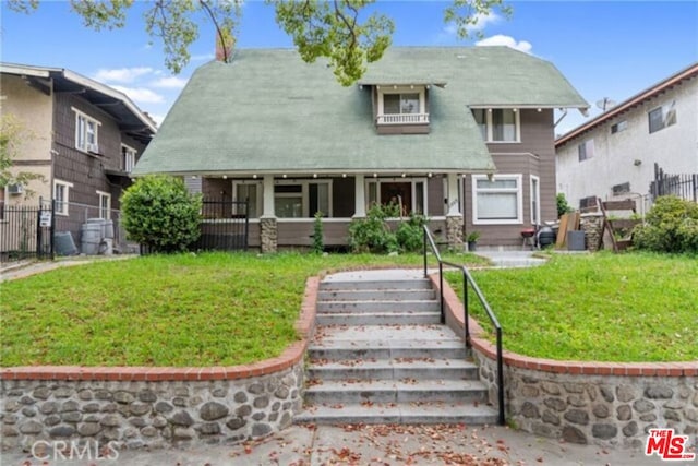 view of front of property featuring covered porch and a front yard