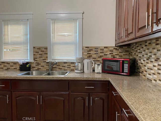 kitchen with tasteful backsplash, sink, and dark brown cabinetry