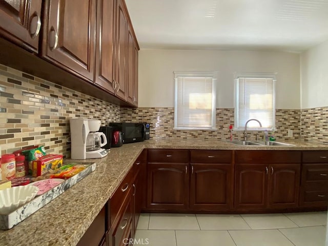 kitchen with light stone countertops, sink, backsplash, and light tile patterned floors