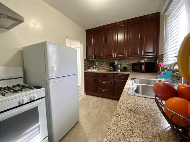 kitchen featuring decorative backsplash, white appliances, light stone countertops, range hood, and sink