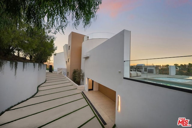 property exterior at dusk with a balcony