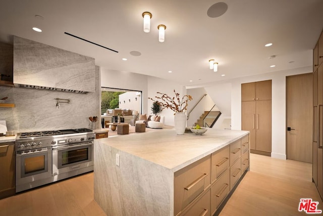 kitchen with backsplash, range hood, a kitchen island, double oven range, and light wood-type flooring