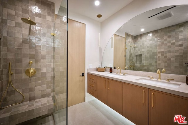 bathroom featuring tile patterned flooring, a shower with shower door, and vanity