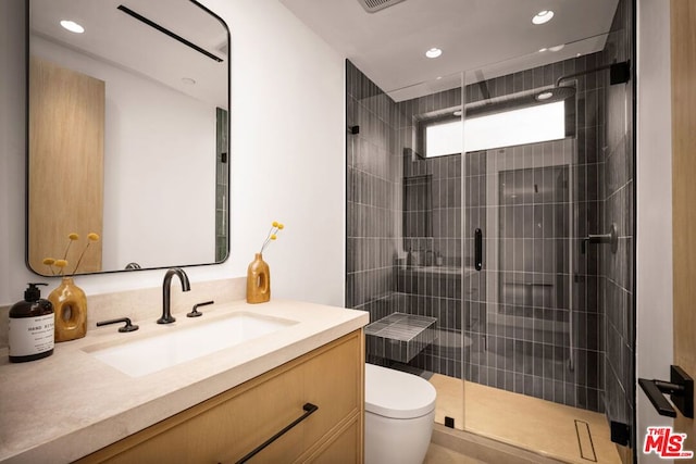 bathroom with toilet, an enclosed shower, and vanity