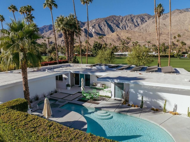 rear view of property featuring a mountain view and a patio area