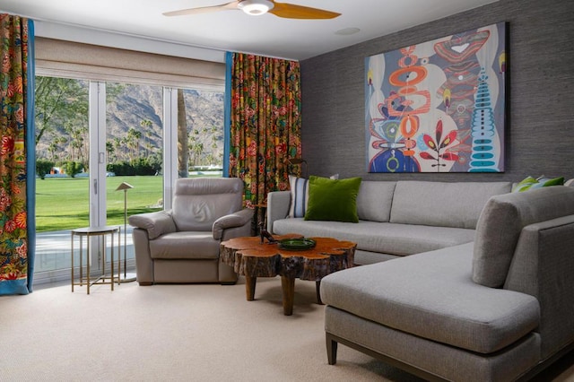 living room with ceiling fan, a mountain view, and carpet flooring