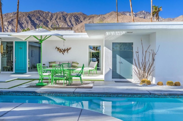 view of swimming pool featuring a mountain view and a patio