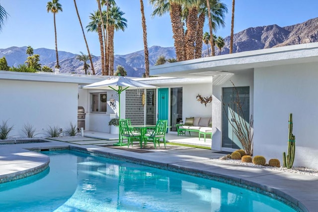 view of swimming pool featuring a mountain view, area for grilling, and a patio