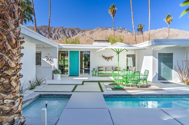 rear view of house featuring a mountain view and a patio