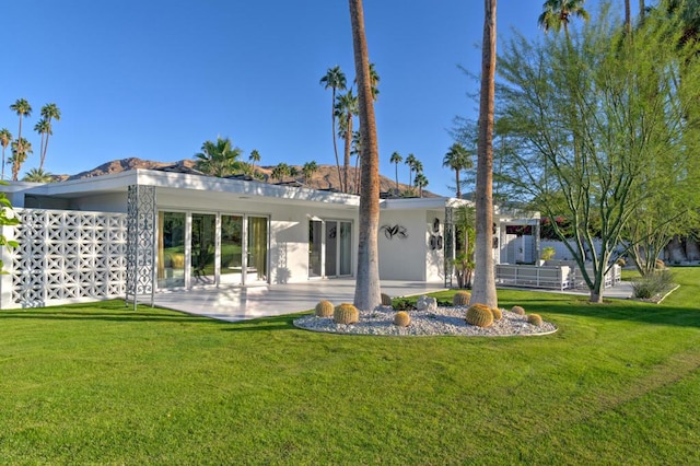 rear view of property with a patio area and a lawn