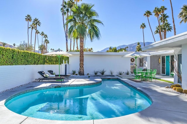 view of pool featuring a mountain view and a patio