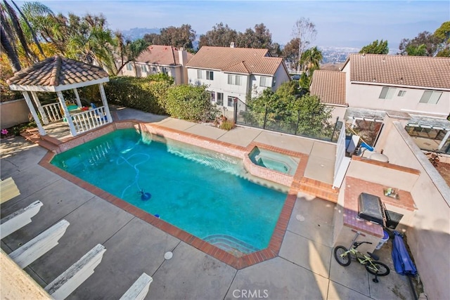 view of swimming pool with a gazebo and an in ground hot tub