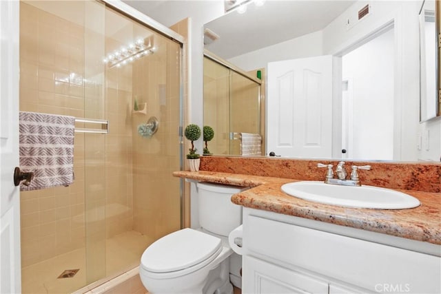 bathroom with an enclosed shower, vanity, and toilet