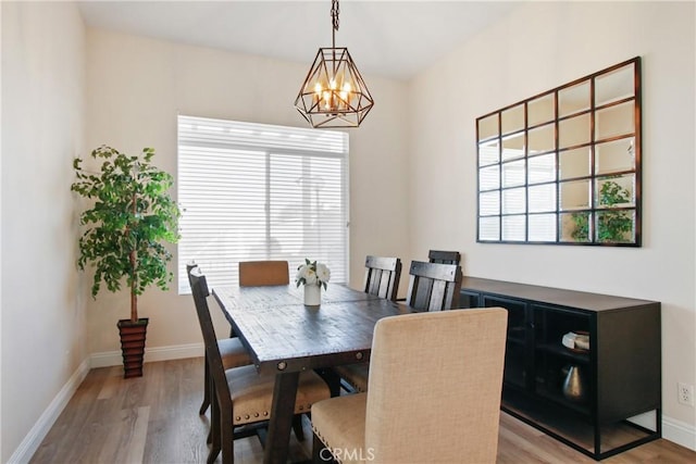 dining space with a notable chandelier and light wood-type flooring