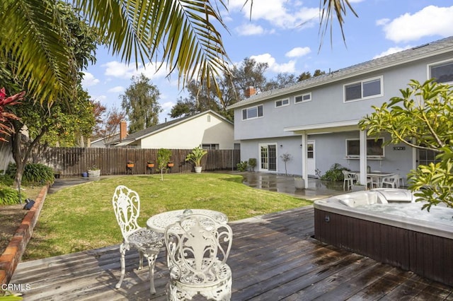 wooden terrace featuring a lawn and a hot tub