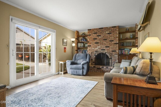 living room featuring a fireplace, crown molding, and light hardwood / wood-style flooring