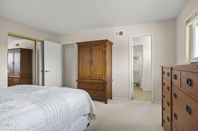 bedroom featuring light carpet, a closet, and connected bathroom