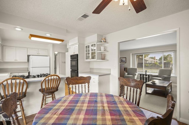 dining space featuring ceiling fan and a textured ceiling