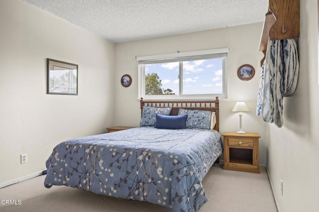 bedroom with a textured ceiling and light colored carpet