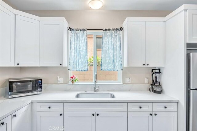 9022 Marlene Ave, Garden Grove, CA 92841 - kitchen with stainless steel appliances, a sink, white cabinetry, and light countertops