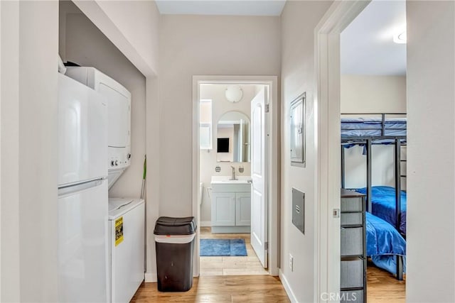 9022 Marlene Ave, Garden Grove, CA 92841 - laundry room with stacked washing machine and dryer, light wood-style floors, and baseboards