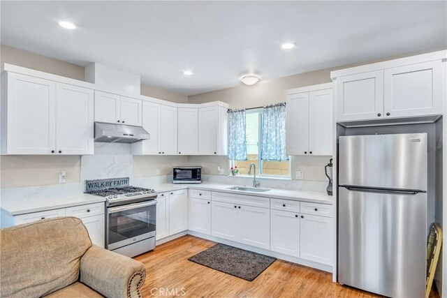9022 Marlene Ave, Garden Grove, CA 92841 - kitchen featuring stainless steel appliances, under cabinet range hood, a sink, light countertops, and white cabinets
