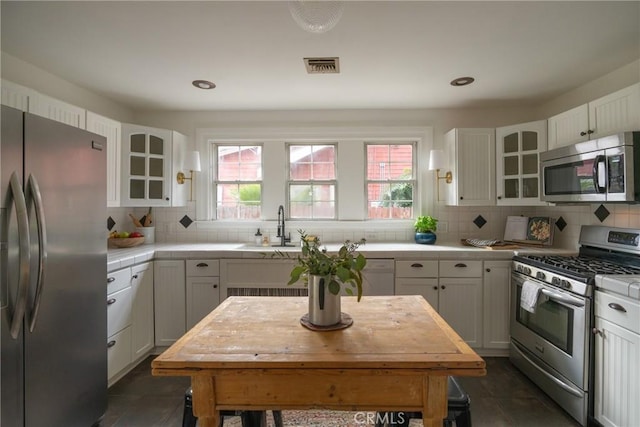 kitchen featuring tasteful backsplash, white cabinets, and stainless steel appliances