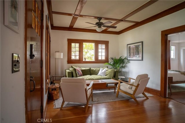 living room featuring hardwood / wood-style flooring, ceiling fan, coffered ceiling, and beamed ceiling