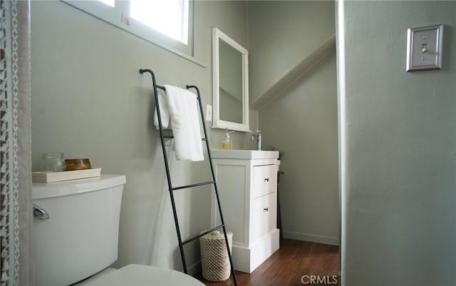 bathroom featuring toilet, hardwood / wood-style flooring, and vanity