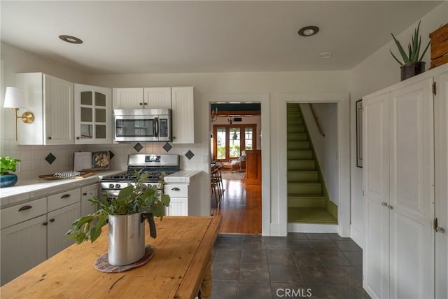 kitchen featuring appliances with stainless steel finishes, white cabinetry, and tasteful backsplash