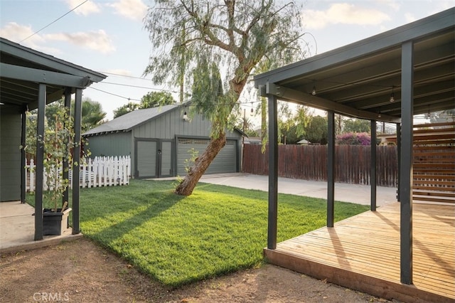 view of yard with an outbuilding, a wooden deck, and a garage